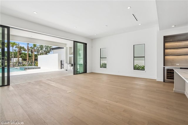 unfurnished living room featuring light wood-style floors, recessed lighting, and baseboards