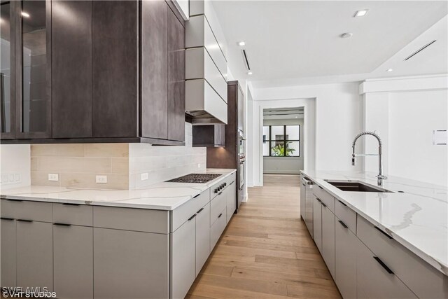 kitchen with a sink, modern cabinets, white stovetop, and recessed lighting