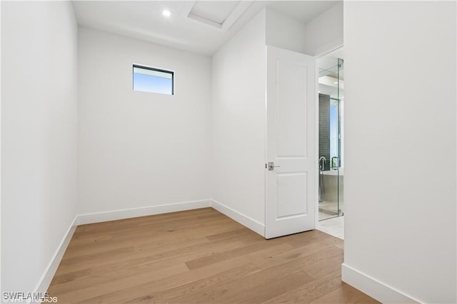 spare room featuring light wood-type flooring, attic access, baseboards, and recessed lighting