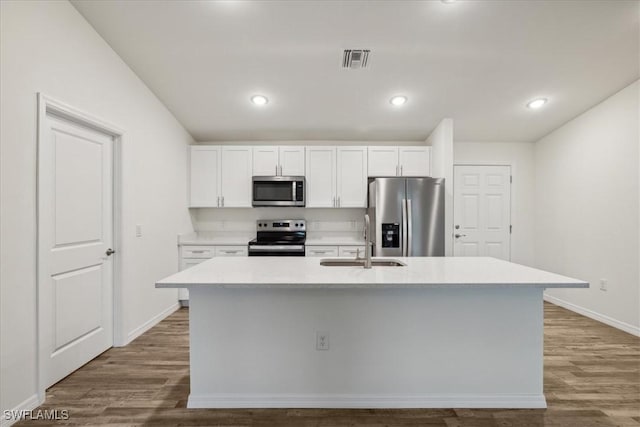 kitchen featuring stainless steel appliances, a sink, baseboards, white cabinets, and recessed lighting