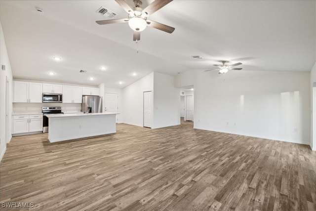 unfurnished living room with ceiling fan, lofted ceiling, light wood-style floors, recessed lighting, and baseboards