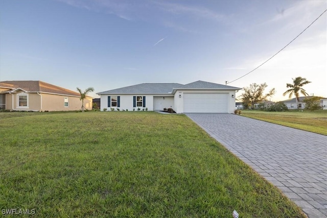 ranch-style house featuring decorative driveway, an attached garage, and a front lawn