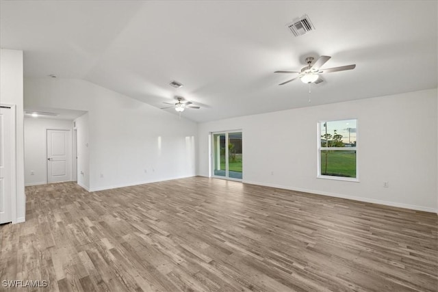 unfurnished living room featuring a ceiling fan, lofted ceiling, light wood finished floors, and healthy amount of natural light
