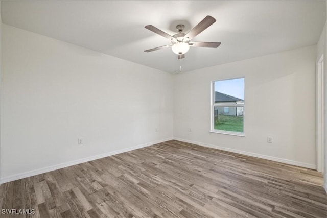unfurnished room with wood finished floors, baseboards, and a ceiling fan