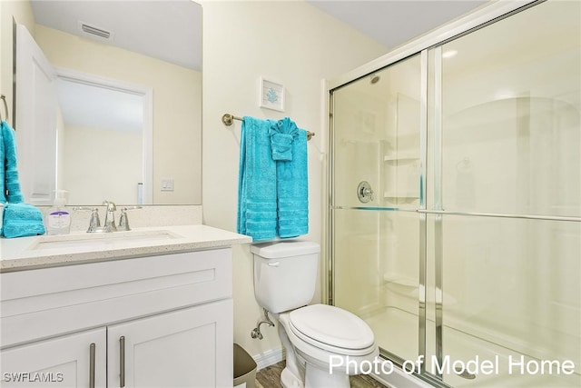 full bath featuring toilet, a shower stall, and vanity