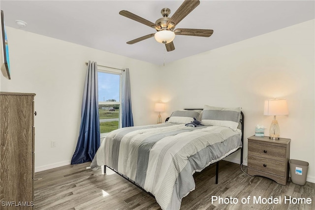 bedroom with wood finished floors, baseboards, and a ceiling fan