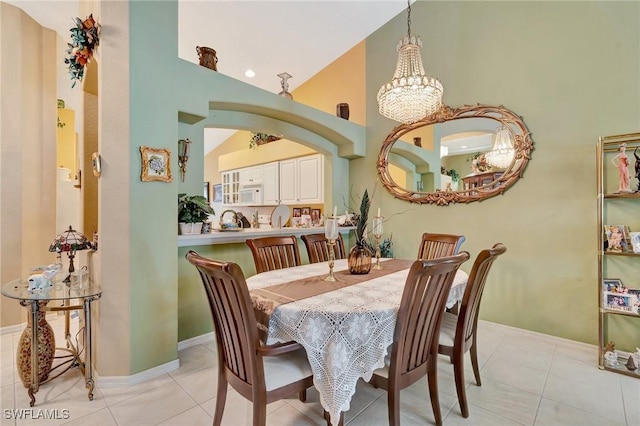 8012 Sivon Way Unit 902, Naples, FL 34119 - dining space with a high ceiling, a chandelier, light tile patterned flooring, arched walkways, and baseboards