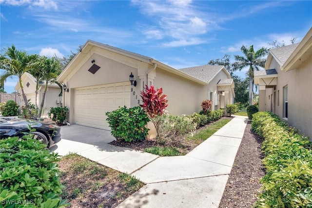 8012 Sivon Way Unit 902, Naples, FL 34119 - view of front of house featuring stucco siding, a garage, and concrete driveway