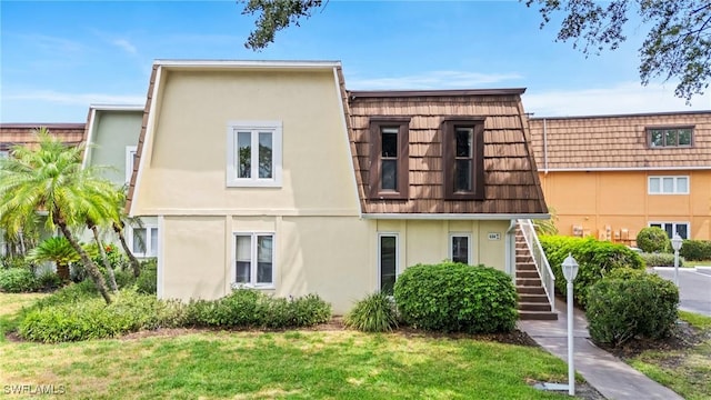430 Meadowlark Ln Unit 430B, Naples, FL 34105 - townhome / multi-family property featuring stairway, stucco siding, mansard roof, and a front lawn