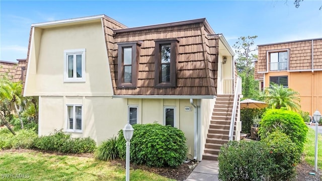 430 Meadowlark Ln Unit 430B, Naples, FL 34105 - view of property featuring stairs, stucco siding, and mansard roof