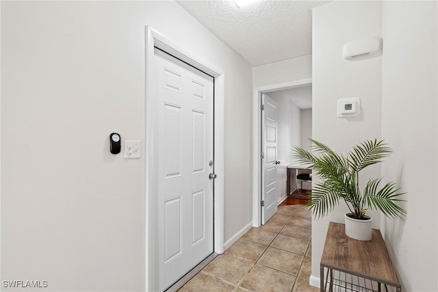 430 Meadowlark Ln Unit 430B, Naples, FL 34105 - doorway to outside with a textured ceiling, light tile patterned floors, and baseboards