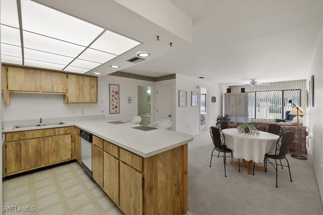 kitchen featuring a sink, open floor plan, a peninsula, light countertops, and dishwashing machine