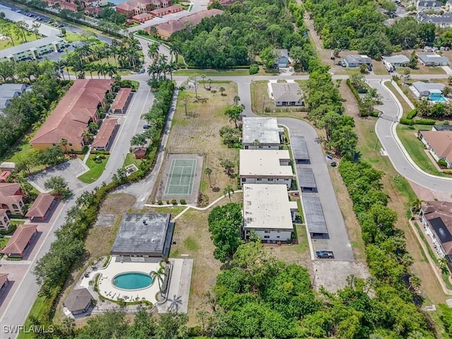 aerial view of property and surrounding area with a pool area and nearby suburban area