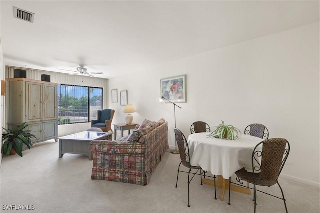 living area featuring carpet floors, ceiling fan, and baseboards