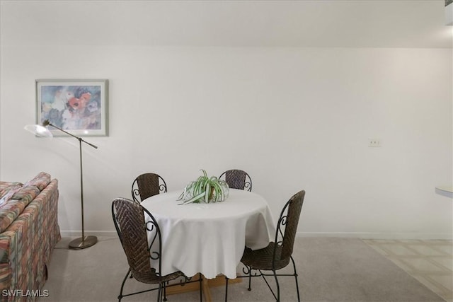 dining space featuring carpet and baseboards