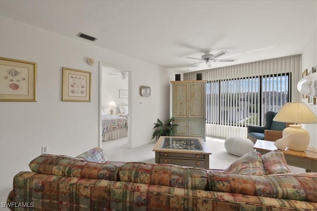 carpeted living area featuring ceiling fan