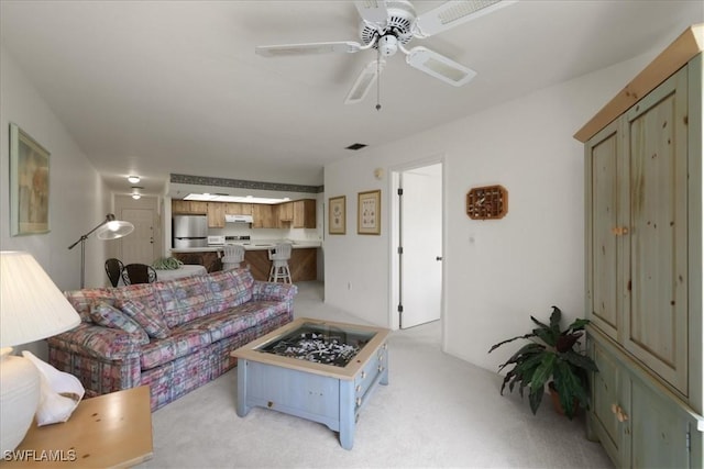 living area with light colored carpet and a ceiling fan