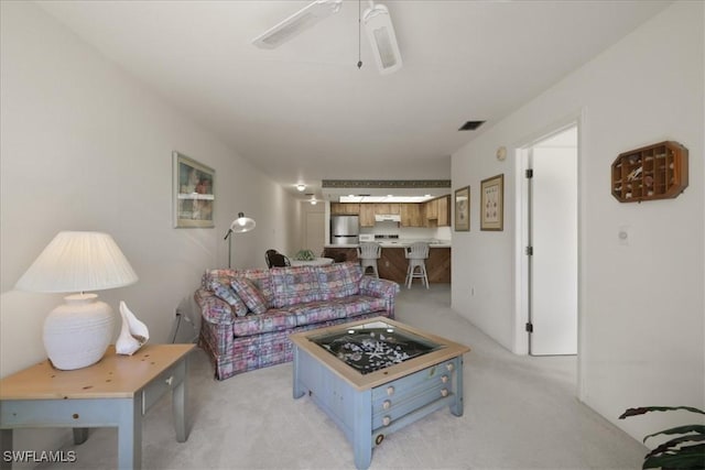 living room featuring light colored carpet and a ceiling fan