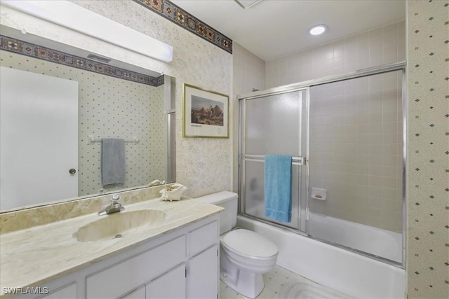bathroom featuring bath / shower combo with glass door, vanity, toilet, and wallpapered walls