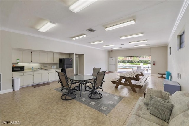 dining area featuring crown molding and light tile patterned floors