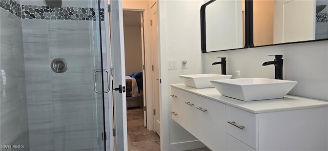 ensuite bathroom featuring a stall shower, double vanity, and marble look tile flooring