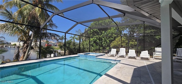 view of swimming pool featuring a patio area, a pool with connected hot tub, a lanai, and a water view