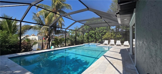 view of swimming pool featuring a patio area, a pool with connected hot tub, a lanai, and a water view