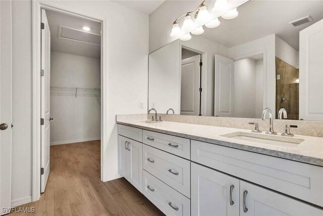 44311 Panther Dr, Punta Gorda, FL 33982 - full bath with wood finished floors, a stall shower, double vanity, a spacious closet, and baseboards