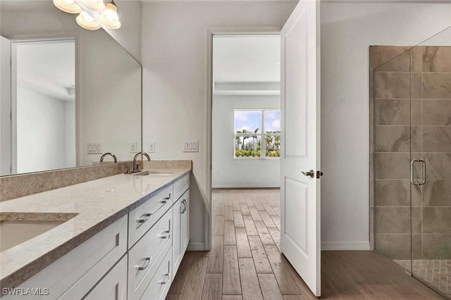 44311 Panther Dr, Punta Gorda, FL 33982 - full bath featuring wood finished floors, a shower stall, baseboards, and double vanity