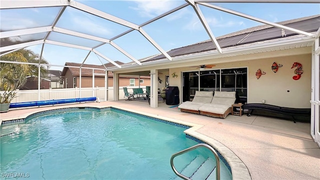 view of pool with a patio area, a ceiling fan, glass enclosure, and fence