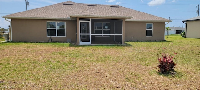 rear view of property with stucco siding, a lawn, a sunroom, and a shingled roof