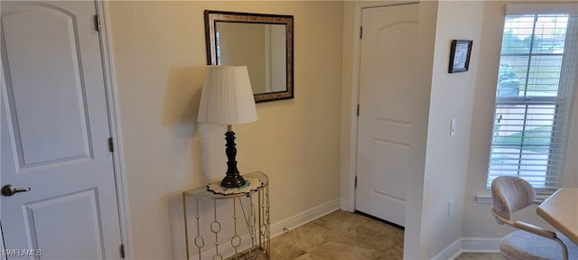 foyer featuring baseboards and healthy amount of natural light