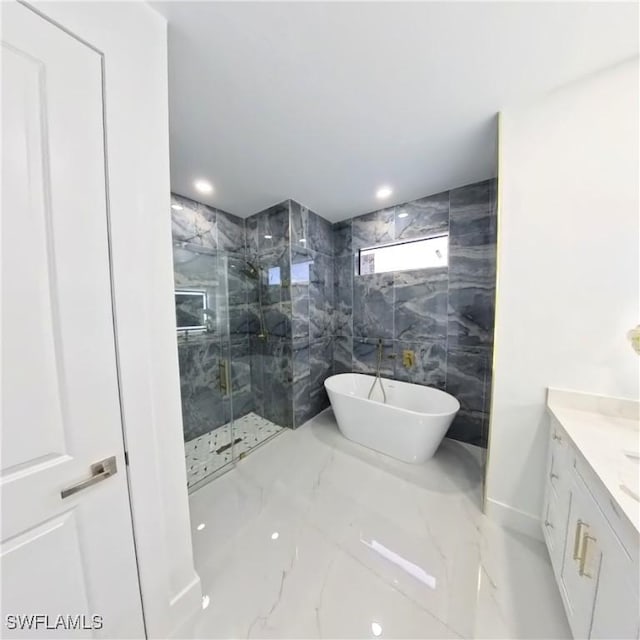 full bath with a marble finish shower, marble tiled floors, a freestanding bath, and vanity