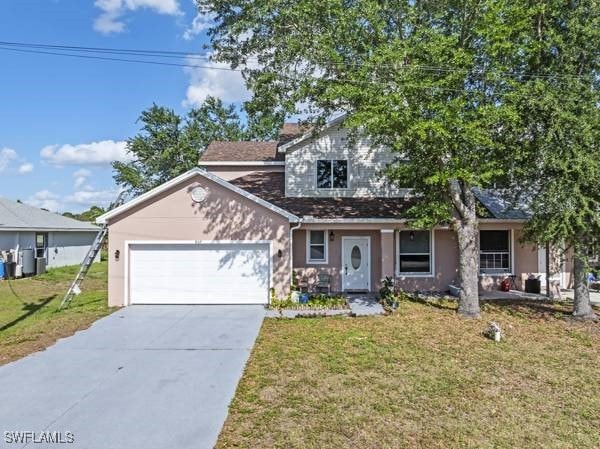 857 Bedford Dr, Lehigh Acres, FL 33974 - view of front of property featuring a garage, a front lawn, driveway, and stucco siding