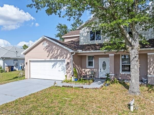 857 Bedford Dr, Lehigh Acres, FL 33974 - view of front of house featuring stucco siding, an attached garage, driveway, and a front yard