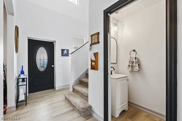 857 Bedford Dr, Lehigh Acres, FL 33974 - entrance foyer featuring light wood-style flooring, stairway, and baseboards