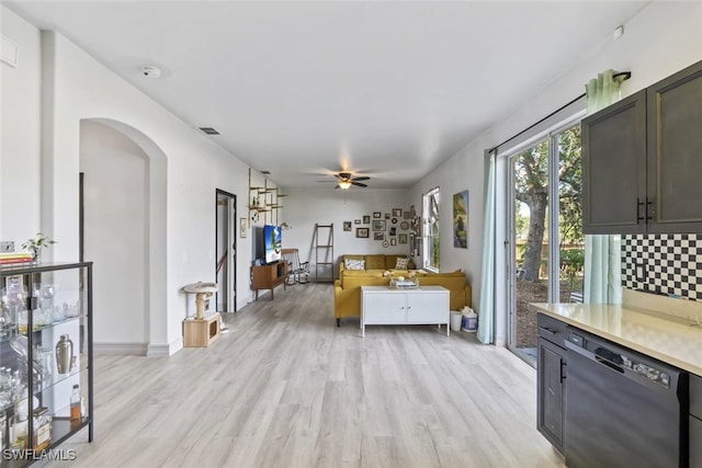 857 Bedford Dr, Lehigh Acres, FL 33974 - living room with arched walkways, light wood finished floors, ceiling fan, and baseboards