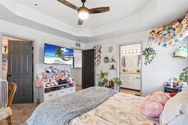 857 Bedford Dr, Lehigh Acres, FL 33974 - bedroom with a tray ceiling, ensuite bath, and a ceiling fan