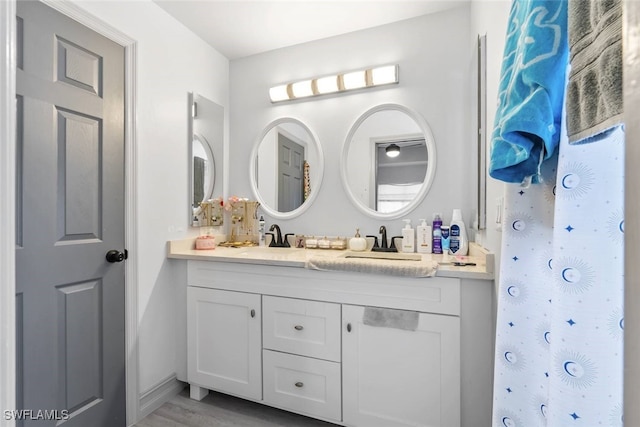 857 Bedford Dr, Lehigh Acres, FL 33974 - full bath with double vanity, baseboards, and wood finished floors