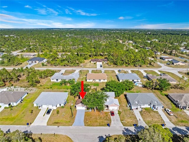 857 Bedford Dr, Lehigh Acres, FL 33974 - aerial view of property's location with nearby suburban area and a forest
