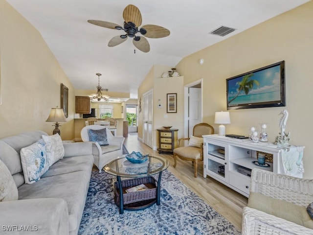 850 Elkhorn Ct Unit 222, Marco Island, FL 34145 - living area featuring light wood-style floors, vaulted ceiling, a chandelier, and a ceiling fan