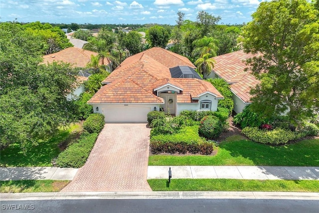 view of front of property with an attached garage, decorative driveway, a tiled roof, and stucco siding