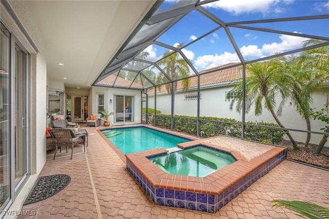 view of pool with a patio, a pool with connected hot tub, and a lanai