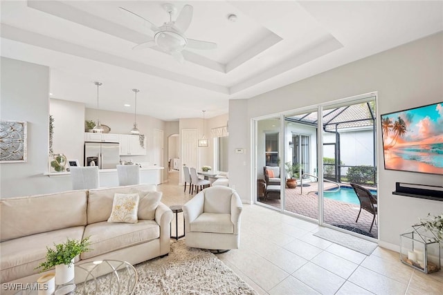 living area featuring a ceiling fan, a raised ceiling, light tile patterned flooring, recessed lighting, and a sunroom
