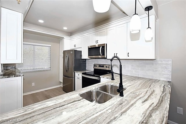 14911 Hole In 1 Cir Unit 310, Fort Myers, FL 33919 - kitchen featuring appliances with stainless steel finishes, light stone countertops, a sink, wood finished floors, and recessed lighting
