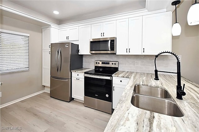 14911 Hole In 1 Cir Unit 310, Fort Myers, FL 33919 - kitchen with appliances with stainless steel finishes, a sink, light wood-type flooring, white cabinets, and light stone counters