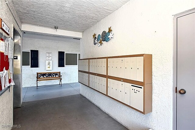 14911 Hole In 1 Cir Unit 310, Fort Myers, FL 33919 - surrounding community featuring a textured wall, mail area, and a textured ceiling