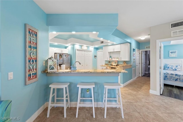10115 Colonial Country Club Blvd Unit 2110, Fort Myers, FL 33913 - kitchen featuring stainless steel fridge with ice dispenser, a peninsula, white cabinetry, and a kitchen breakfast bar