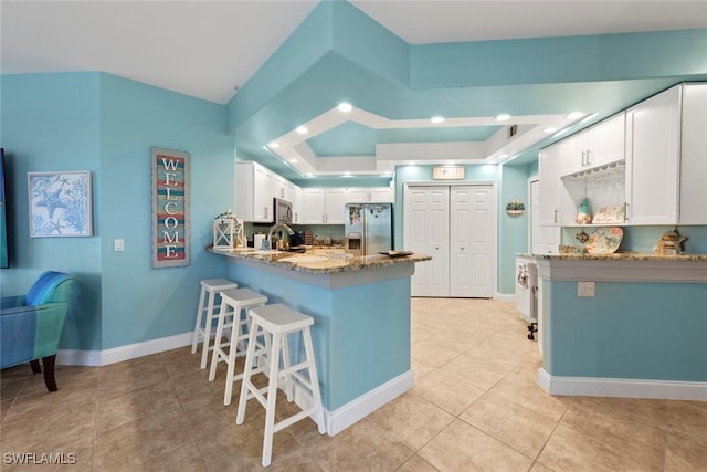 10115 Colonial Country Club Blvd Unit 2110, Fort Myers, FL 33913 - kitchen with stainless steel appliances, a peninsula, light stone countertops, a kitchen bar, and a raised ceiling