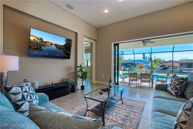 living area with tile patterned flooring, a ceiling fan, and baseboards